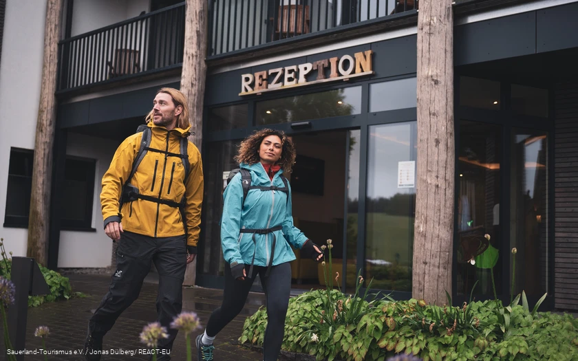 Zwei Wanderer starten ihre Wanderung am Hotel vor der Rezeption
