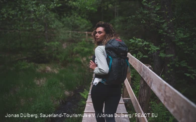 Wandererin auf dem Holzsteg in den Ebbemooren