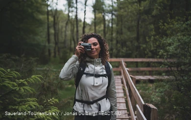 Eine Fotografinauf dem Steg der Ebbemoore