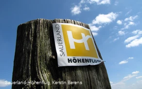Markierungszeichen Sauerland-Höhenflug vor blauem Himmel