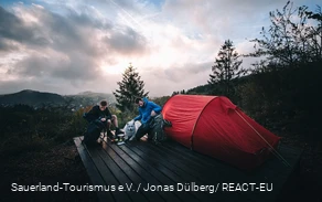 Zwei Männer richten sich auf einem Trekkingplatz ein