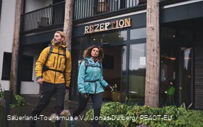 Zwei Wanderer starten ihre Wanderung am Hotel vor der Rezeption