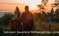 Wanderpaar vor Sonnenaufgang am Eisenberg in Korbach
