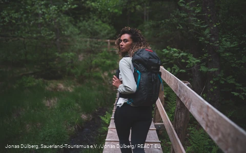 Wandererin auf dem Holzsteg in den Ebbemooren