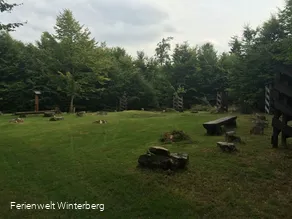 Platz auf einer Wiese mit einigen Holzbänken.