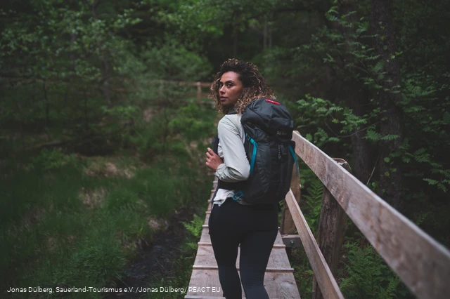Wandererin auf dem Holzsteg in den Ebbemooren