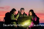 Der Ranger zeigt zwei Wanderern auf einer Karte den Weg