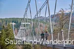Ein Paar läuft über eine Hängebrücke.
