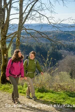 Zwei Wanderer wandern fröhlich nebeneinander oberhalb von Attendorn in Windhausen