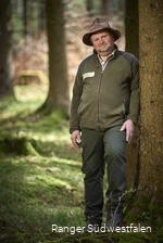 Ein Ranger steht im Wald.