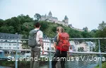 Zwei Wanderer blicken unten von der Lenne auf die Burg Altena