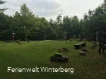 Platz auf einer Wiese mit einigen Holzbänken.