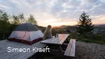 Eine Frau genießt den Sonnenaufgang am Trekkingplatz Talblick